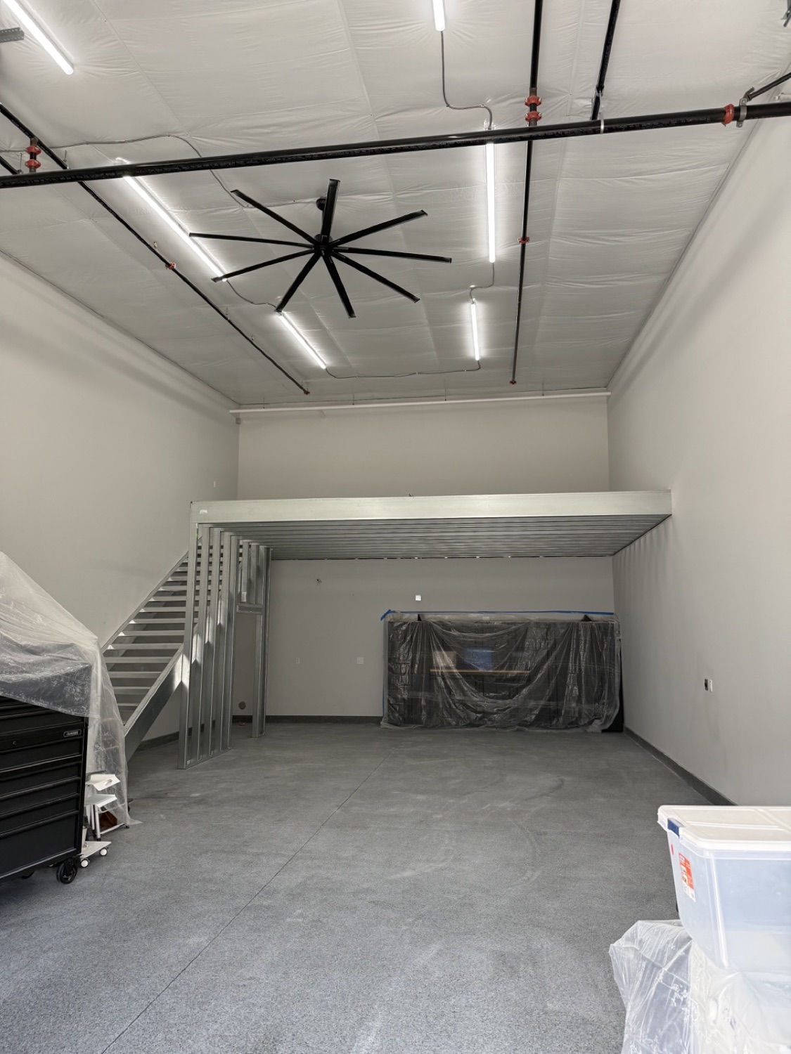 Compact mezzanine platform with a side stair in a bright garage condo